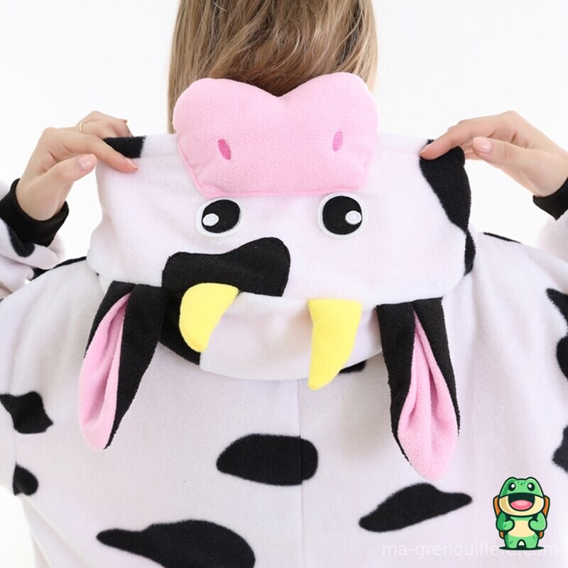 Grenouillère vache rose portée par un adulte en intérieur